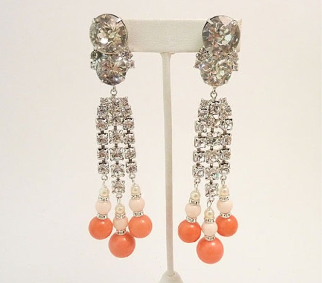 These one of a kind vintage Robert Sorrell earrings feature light and dark faux coral stones with faux pearls and rhinestone accents in a silver-tone setting.  These long clip earrings measure 4 ¾? x 1 ¼? and are in excellent condition.