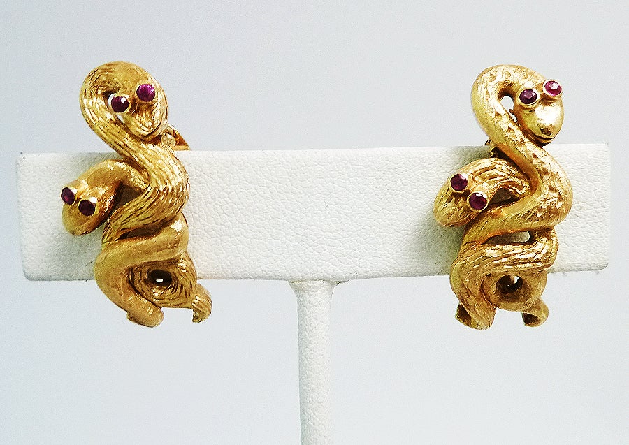 These 18k yellow gold clip-on snake style earrings have genuine ruby eyes. The earrings have a total weight of 20.7 grams and measure 1 1/8x1/2