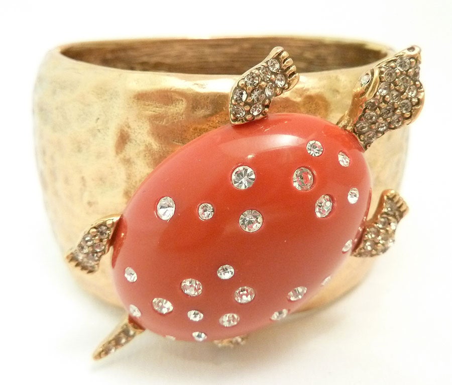 This vintage signed Oscar de la Renta bracelet features a 3-dimensional turtle with a red shell and citrine and clear rhinestone accents in a gold-tone setting.  This piece measures 6 ½ inches  around the inside x 1 ¼ inches  wide with a spring