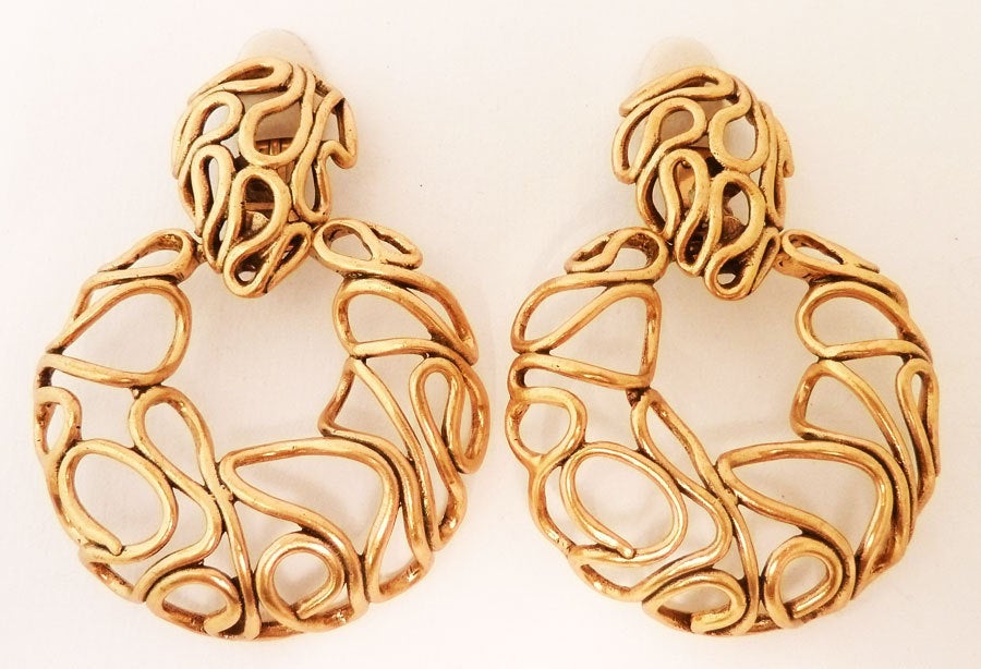 These vintage signed Oscar de la Renta feature a swirling open-work design in a gold-tone setting.  In excellent condition, these clip earrings measure 3 inches  x 2 1/8 inches  and are signed Oscar de la Renta.