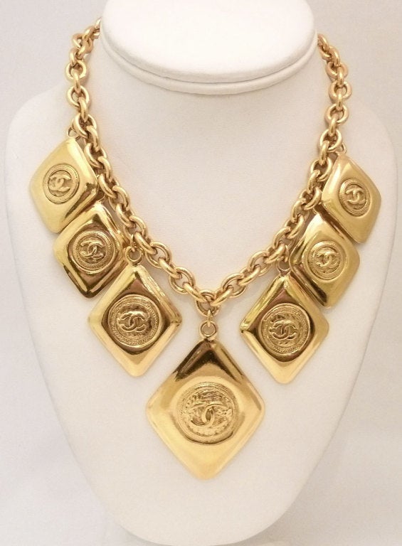 This vintage signed Chanel necklace features 7 pendants with the CC long in a gold-tone setting.  In excellent condition, this necklace measures 15 inches, the largest pendant is 1 ½ inches x 1 ¾ inches and has a spring closure.  In excellent
