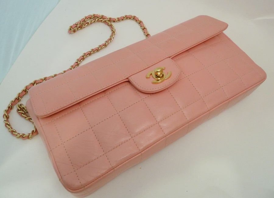 This famous quilted purse by Chanel features pink leather with gold-tone accents.  This purse measures 10 Ã?½inches x 5 1/4inches x 1 1/4inchesand the chain is 12 1/2inches up from center.  Inside are two slide pockets.  In excellent condition, this