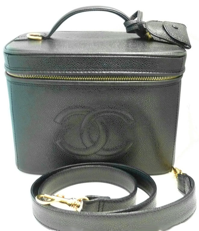 This vintage signed Chanel Italy vanity features black textured leather with gold-tone accents. This purse measures 9 1/2