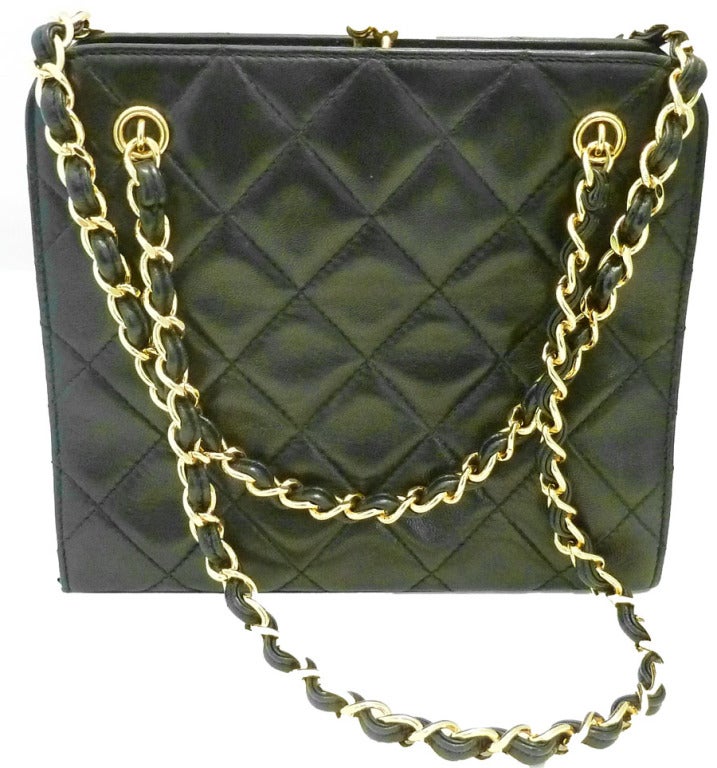 This vintage signed Chanel purse features the famous quilted design in a black leather with gold-tone accents. This purse measures 7 1/2