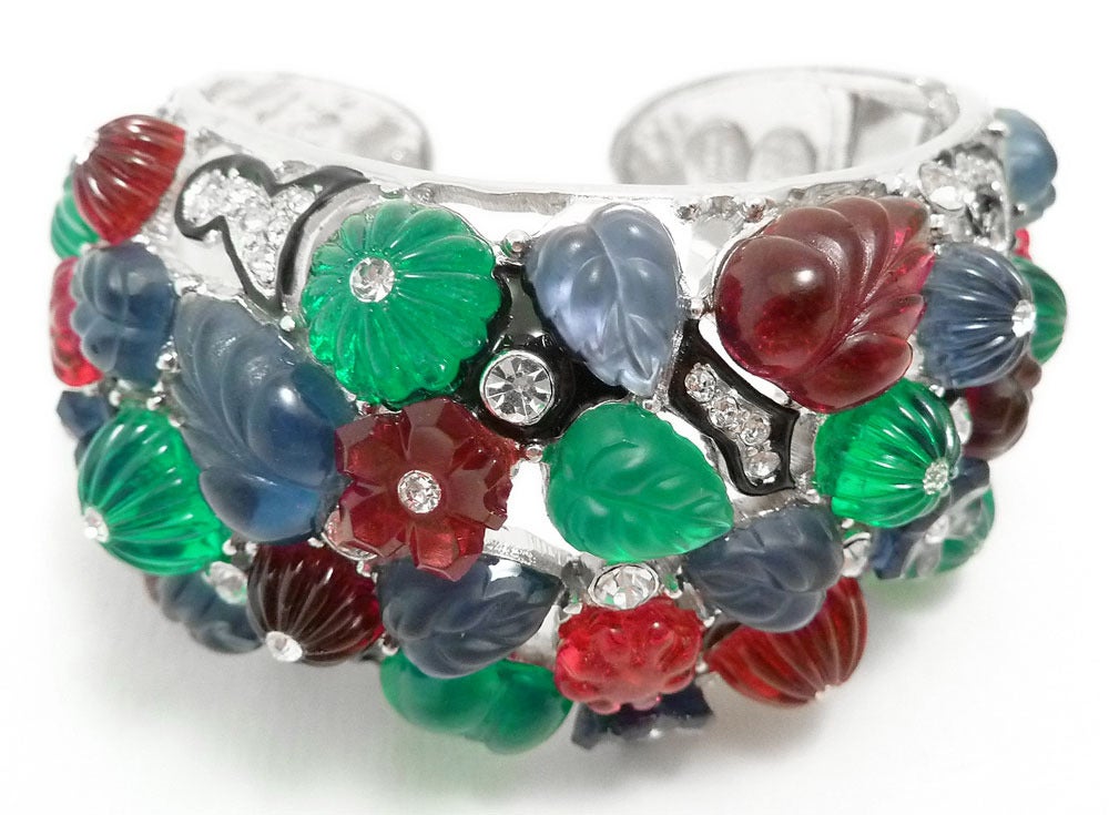 This signed Kenneth J. Lane bracelet features red, green, blue, amethyst color resin leaves with clear rhinestones and black enamel accents in a silver-tone rhodium setting. This bracelet measures 6 1/2