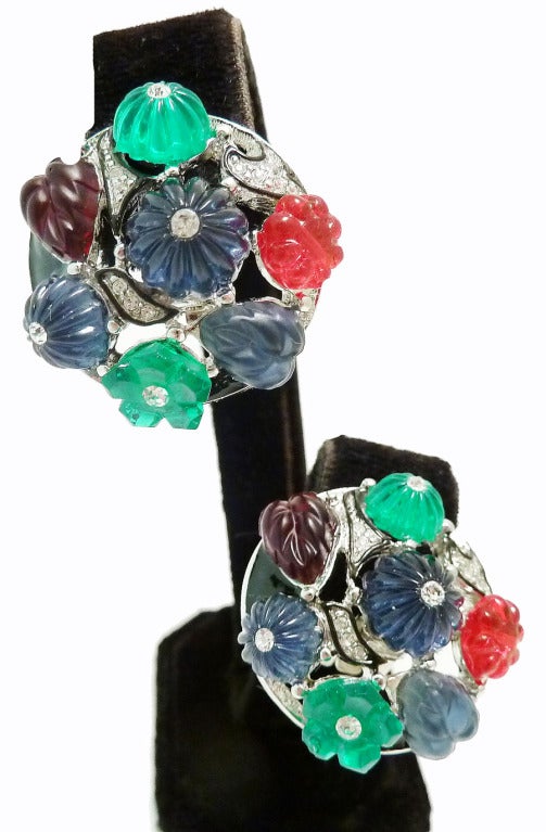 These signed Kenneth J. Lane earrings features red, green, blue and amethyst color glass leaves with clear rhinestones and black enamel accents in a silver-tone rhodium setting. These clip earrings measure 1 1/8