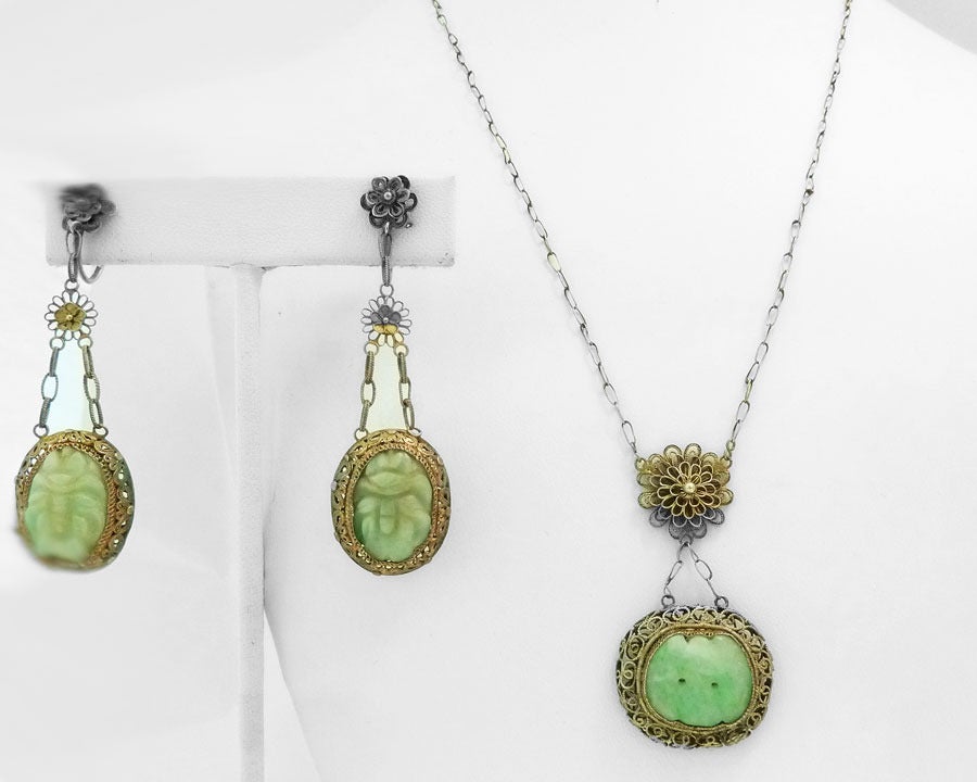 This vintage Art Deco set features a carved Asian design in jade with a sterling silver setting.  The pendant measures 1 ¾” x 1” and the necklace is 18” x 1/1/6” with a screw-barrel closure.  The screw-on earrings are 2 3/8” x 5/8”.  This jade and