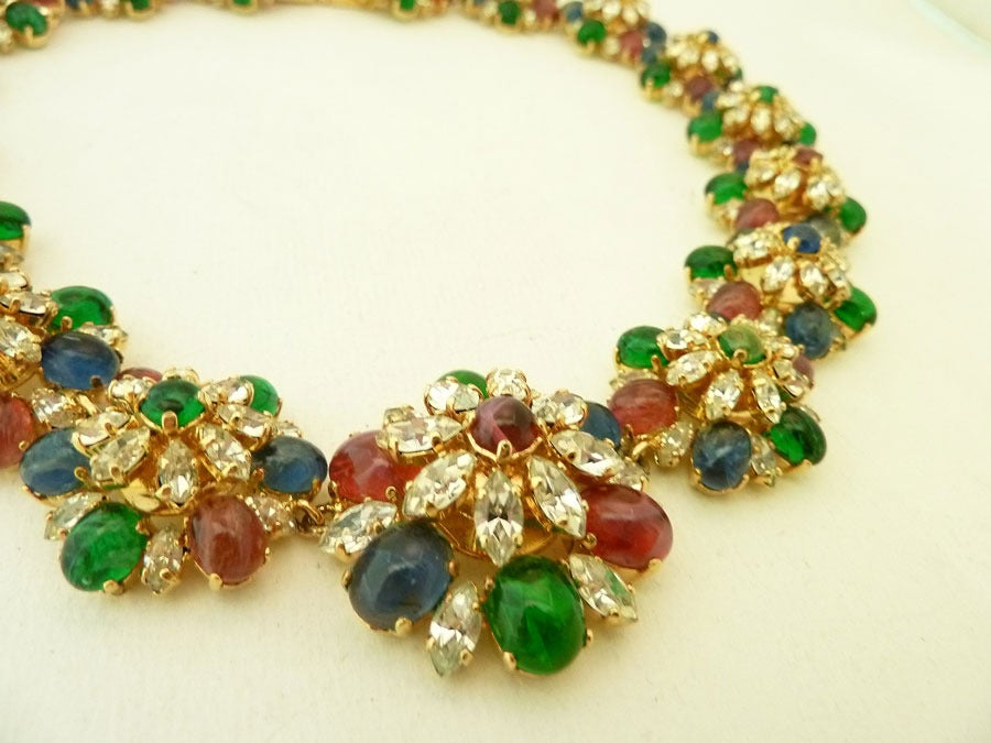 This vintage signed Christian Dior necklace features cranberry, blue and green Gripoix glass stones with clear rhinestone accents in a gold-tone setting.  In excellent condition, this piece measures 18 inches with a pressure closure x 1 1/8 inch. 