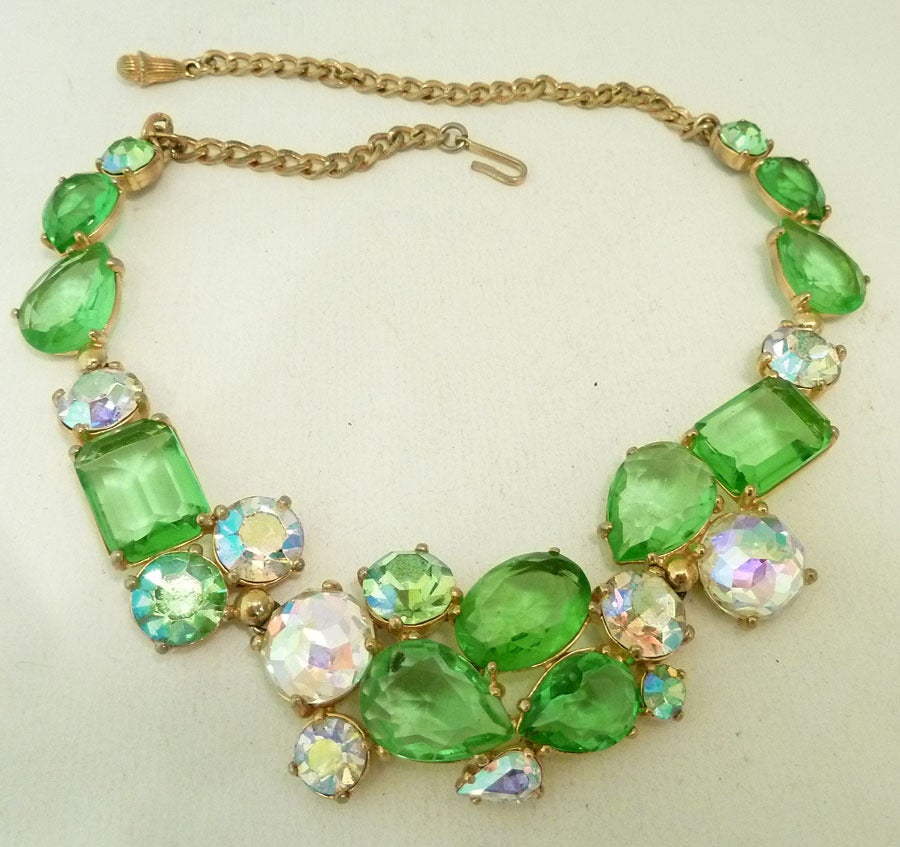 This vintage signed Schiaparelli necklace features  happy green rhinestones and clear aurora borealis rhinestones in a gold-tone setting. The color is amazing and makes this Schiaparelli important enough to go into a good collection.   In excellent