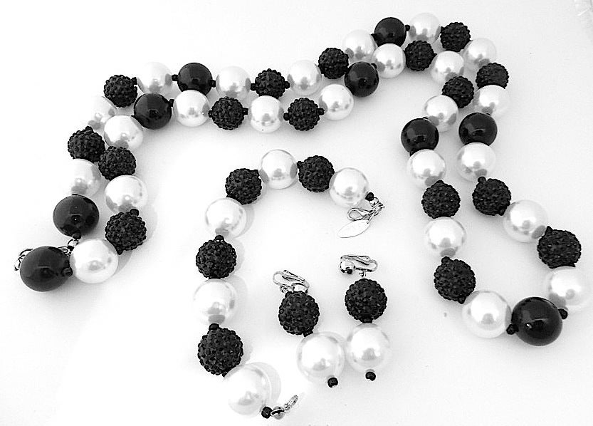 This one of a kind signed R. E. Roselli set feature black ridged beads with faux pearls in a silver-tone setting.  It is simple but it stands out and makes people notice you.   The necklace measures 40” long x ¾” with a spring closure; the bracelet