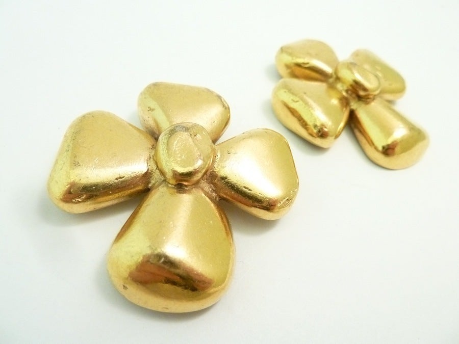 These vintage signed Yves St. Laurent earrings feature a bow design in a gold-tone setting.  In excellent condition, these clip earrings measure 1 7/8