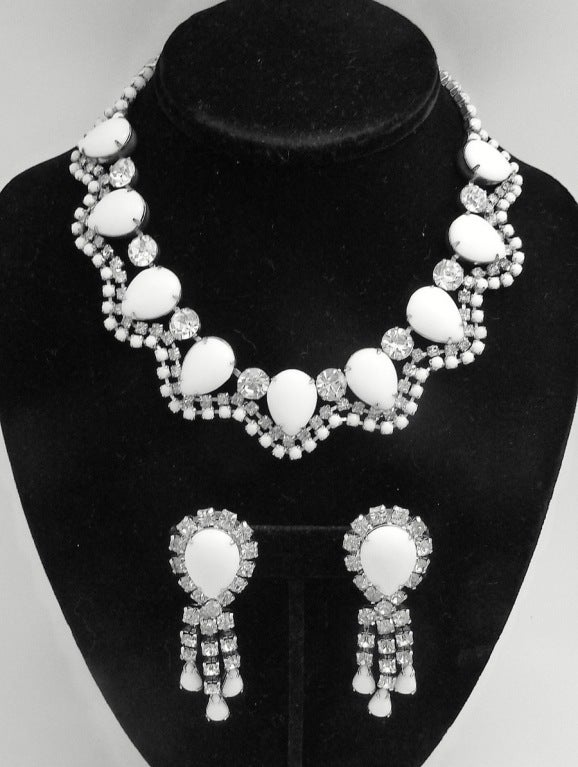 This vintage unsigned Weiss set features white milk-glass and clear rhinestones in a silver-tone setting.   In excellent condition, the necklace measures 16” long with a hook closure x 1” and the clip earrings are 1 3/8” x 7/8”.