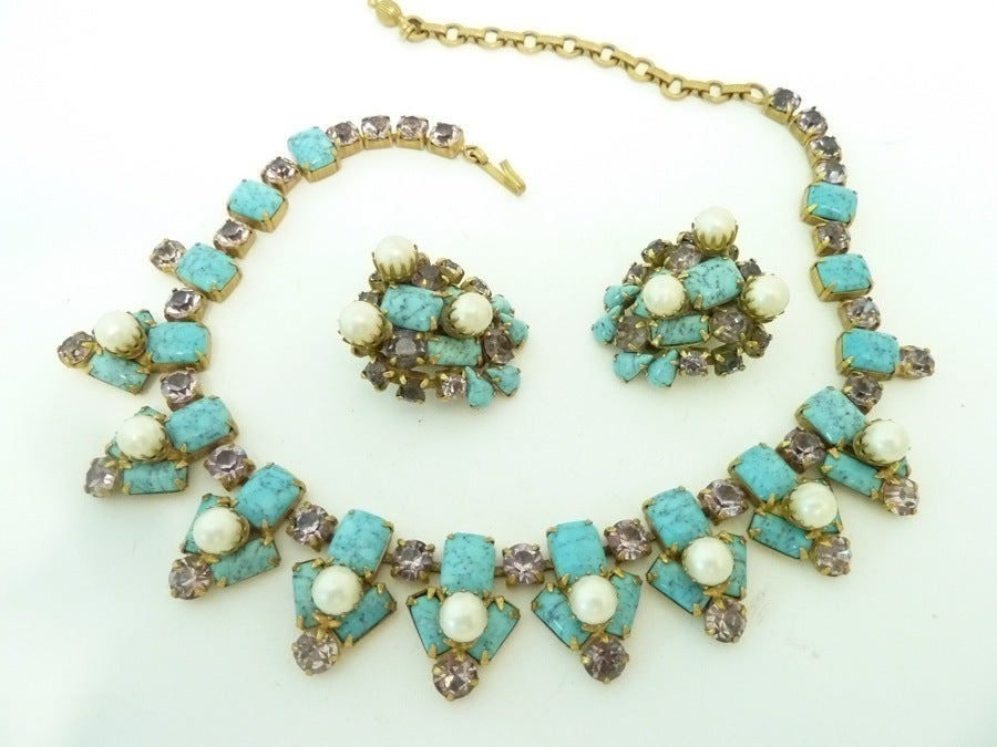 This is the famous Schreiner faux turquoise set as shown on collectible  websites with faux pearls and amethyst rhinestone accents in a gold-tone setting.  The necklace measures 16” with a hook closure x 1”; the clip earrings are 1 ¼” x 1 1/8”. 