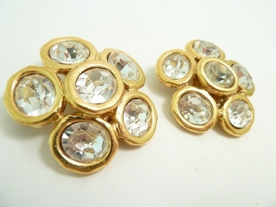 These vintage signed Chanel earrings feature faceted clear crystals in a gold-tone setting. In excellent condition, these clip earrings measure 1 ¾” and are signed Chanel 29 Made in France.