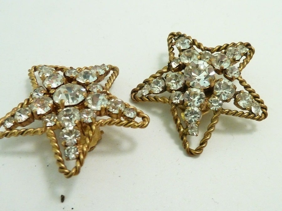 These vintage Chanel earrings feature a star design with clear rhinestone accents in a gold-tone setting. In excellent condition, these clip earrings measure 1 ½” in diameter and are signed Chanel 1983.