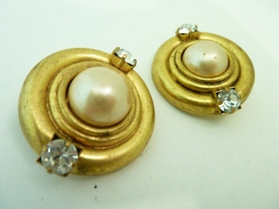 These vintage signed Chanel earrings feature cabochon cut faux pearls in a gold-tone setting. In excellent condition, these clip earrings measure 1 ¼” in diameter and are signed Chanel Made in France.