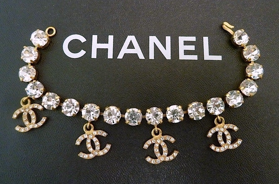 This vintage Chanel bracelet features 4 CC logo charms with clear rhinestone accents in a gold-tone setting. In excellent condition, this bracelet measures 7” with a hook closure and the charms are 5/8”
