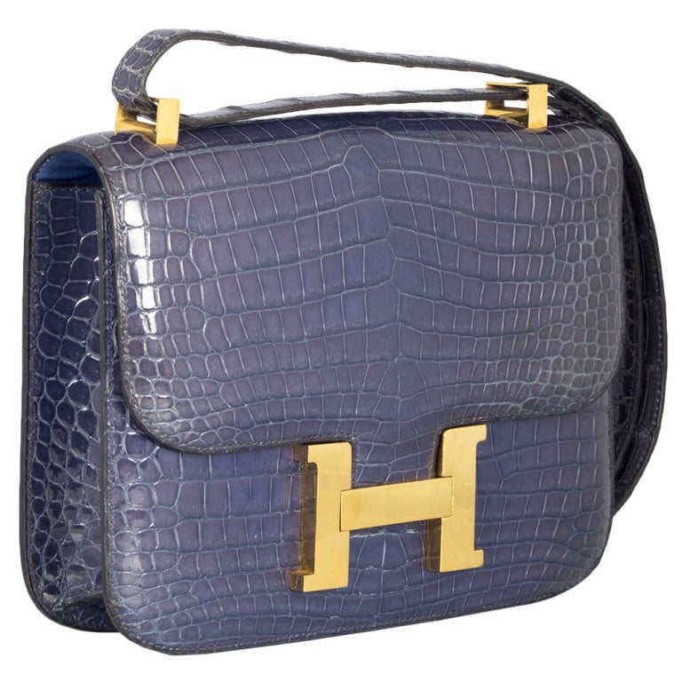 This is a highly collectible vintage Hermes bag. The porosus crocodile vintage Hermes Constance bag comes in a unique and extremely rare Bleu Roi colour.  The interior features two pockets, one zipped. Combined with the gold-tone large 'H' hardware,