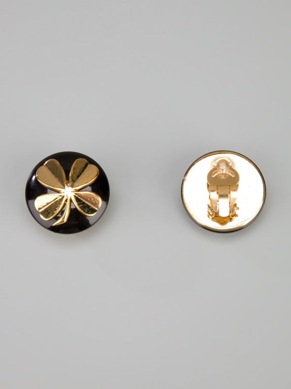 Black clip on earrings from Chanel Vintage featuring a black circle front, a gold tone clover detail and a gold tone clip on back.

Returns Policy: Final Sale - No Returns.

All of our items are shipped from the UK, as a result you may be liable