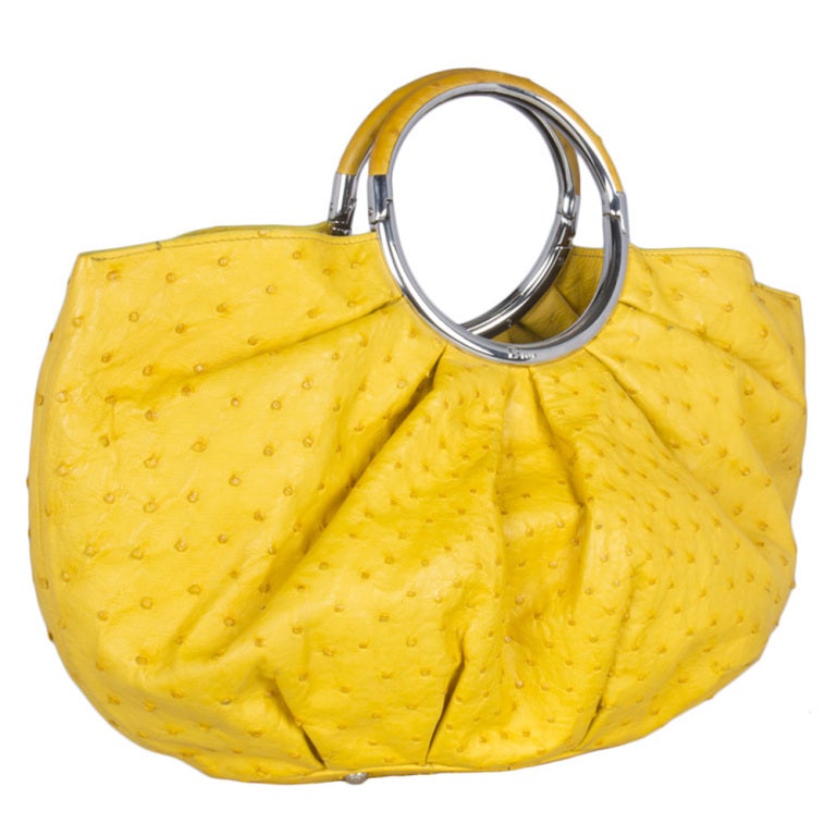 Yellow Ostrich skin Dior bag with silver hardware and suede lining. This bag comes with a detachable purse that can be used separately as an evening clutch or as a separate inner compartment.

Returns Policy: Final Sale - No Returns.

All of our