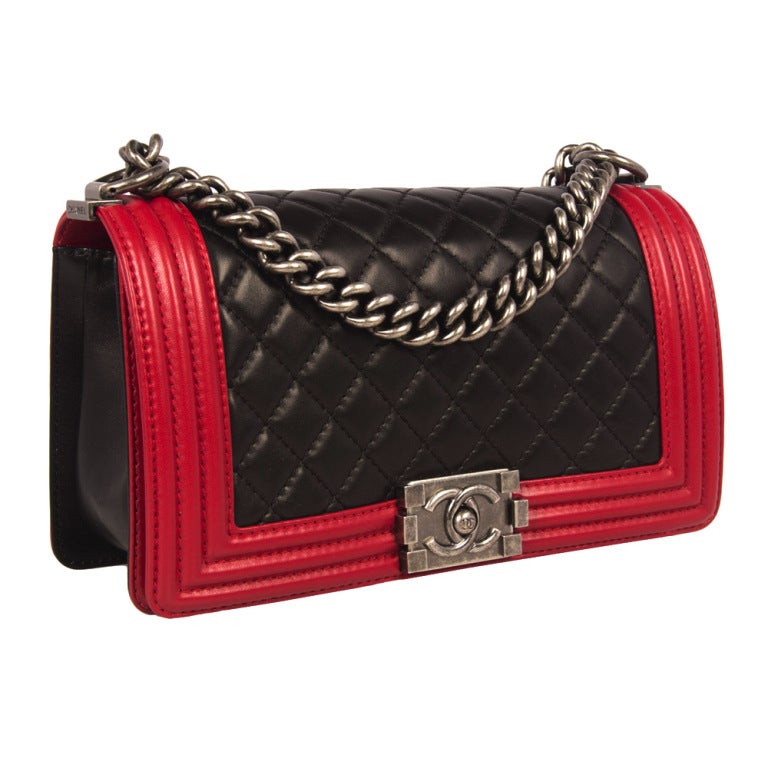 Chanel Boy flap Bag from the Spring/ Summer 2013 collection. With striking black and red lambskin leather and gunmetal hardware this bag is a real statement piece. The interior is lined with red nylon with one pocket. This bag is in pristine