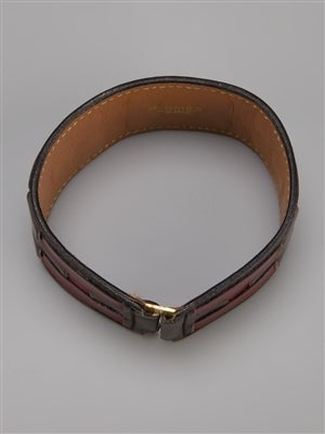 This cuff from Hermès is made of brown leather and features red cut-out leather logo detailing and a concealed gold-tone hook fastening. 

Colour: Red, Brown

Material: Leather

Measurements:  Circumference: 16cm, W: 3cm

Returns Policy: