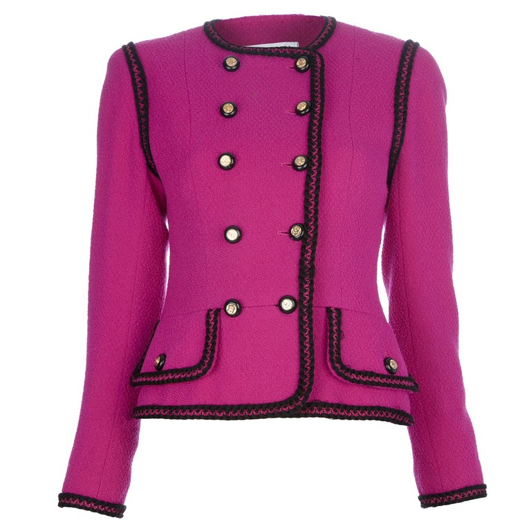 Fuchsia wool vintage suit from Chanel featuring a double breasted jacket and matching skirt. The brightly-coloured wool is complemented by a border of black stitching, providing a sharp tailored look. Team this with your highest stilettos for a