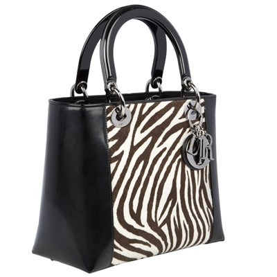 Small Dior Lady Bag is crafted in patent leather with zebra print panels and accented with gun-metal hardware. The lining is made of canvas and has one zipped pocket.

Material: Patent leather, pony hair, gunmetal

Measurements:  W: 24cm H: 20cm