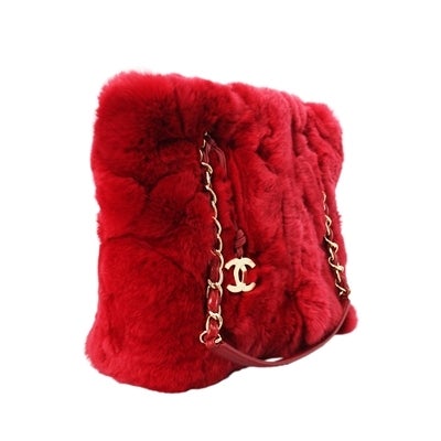 This beautiful bag comes in bold red rabbit fur and features the classic chain and leather double straps and a hanging Chanel logo pendant. Inside the bag is lined in matching red leather and holds one zipped pocket and a phone