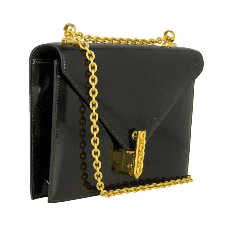 This stunning Hermes Alcazar bag comes in box black leather and features gold-tone hardware and chain shoulder strap. Inside the bag holds one compartment, one zipped pocket and two open sleeve pockets, embossed with the Hermes logo. The most