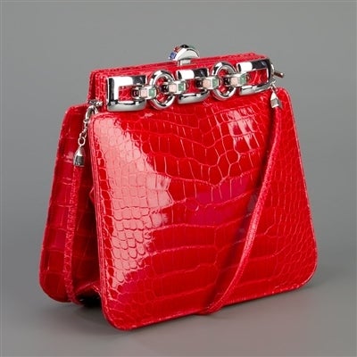 Red aligator leather bag from Judith Leiber Vintage featuring a snap fastening, a skinny shoulder strap, an interior pocket with logo plaque and a separate purse and comb.