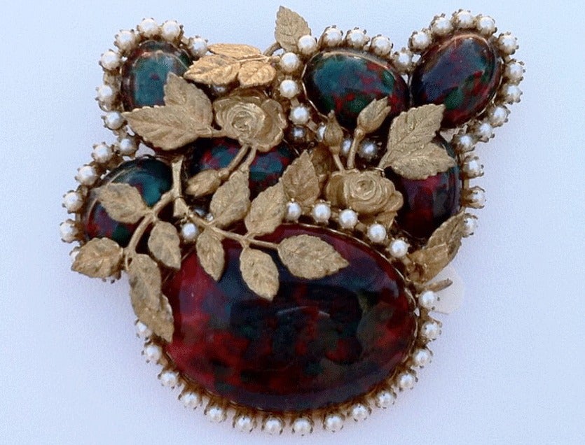 Exquisite vintage Miriam Haskell prototype brooch. Large signed gilt metal item features oval faux bloodstone glass cabochons with faux seed pearl surrounds. Item delicately entwined with gilt roses. Item displays great depth and charm. Original pin