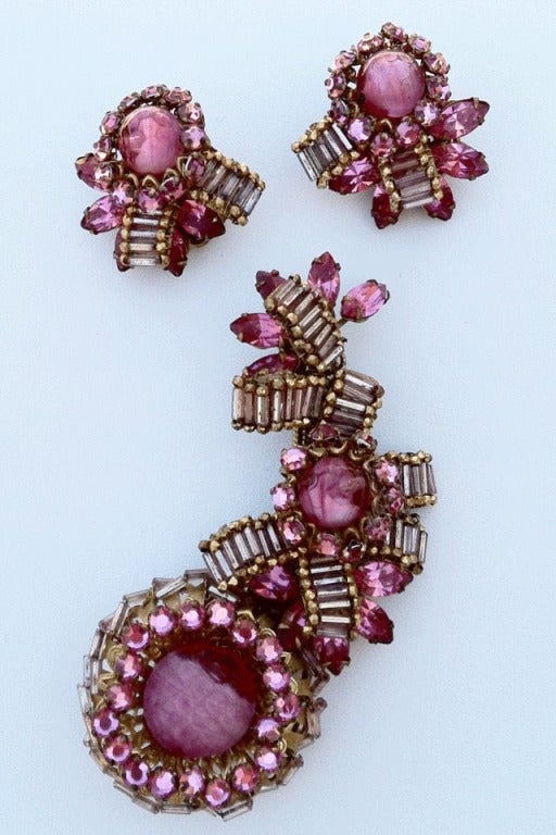 Fine vintage Miriam Haskell prototype brooch and ear clip suite. Signed gilt metal items feature pink molded art glass centers. Items threaded with silver glass bugle beads and pink Swarovski crystal surrounds and accents. Suite retains original pin