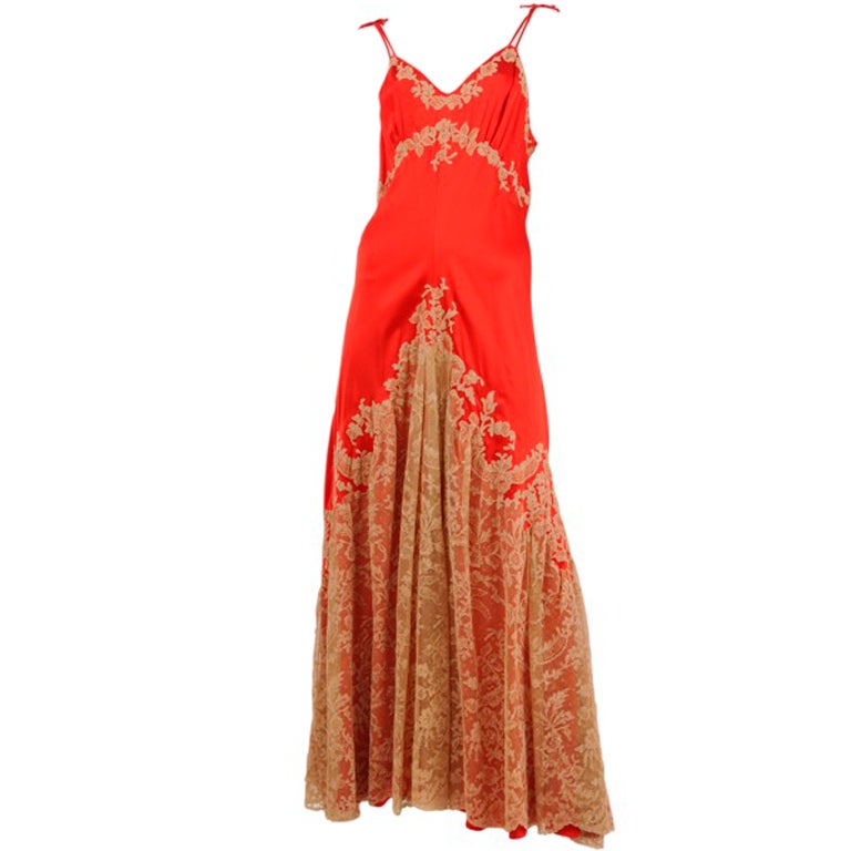 Fire red and silk satin gown with entire skirt decorated in delicate beige lace and continued on bodice.