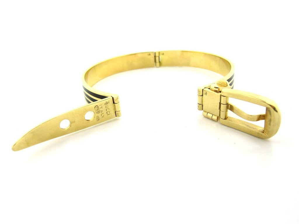 1960-70's Buckle motif bracelet by Gucci. Rare and collectible. Composed of solid 18 karat yellow gold & enamel. Fully working buckle clasp. Keep in mind the enamel striping in the images appears to be all black, however the 2 outer enamel stripes