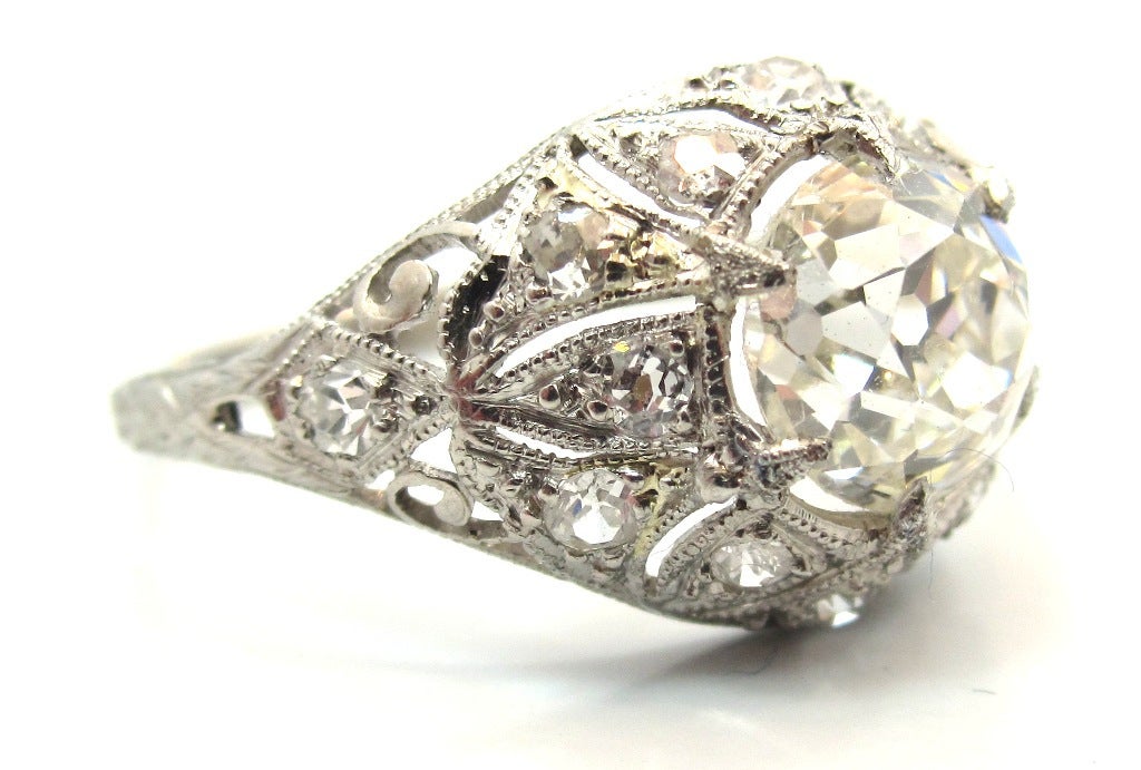 This wonderful example of Edwardian Era hand craftsmanship is composed of platinum with a beautiful pierced openwork & filigree design.
 Featuring a center stone 1.73 Carat Old Mine Cut diamond. Accompanied by a Professional Gem Sciences Laboratory