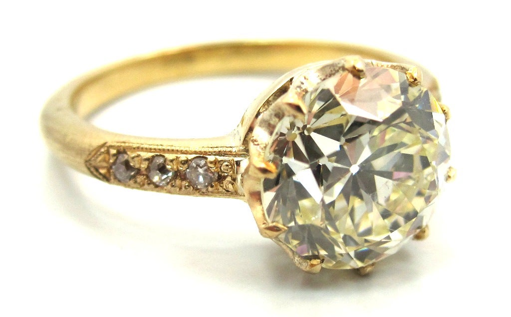 Elegantly handcrafted in 18 karat yellow gold this rare version of an Edwardian era engagement ring (circa 1905) features a center stone 2.73 Carat Old European Cut diamond. Delicately prong set in a 