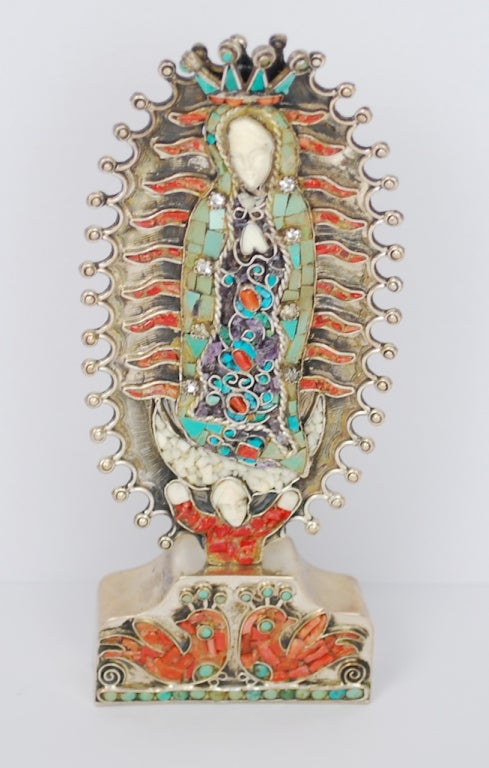 An extraordinary piece by Matilde Eugenia Poulat MATL.  This silver Lady of Guadalupe is absolutely a treasure. Encrusted with turquoise, amethyst, coral, topaz and carved bone. This precious work of art is further enhanced by its copper and glass