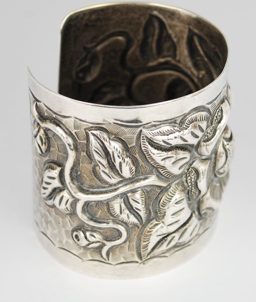 This is the second of a rare collection of  six exceptional cuffs.  These are   Mexican Repousse Silver cuffs all made in Mexico City in the early 20th C.  This cuff  is a powerful and spectacular. The maker TOBIAS was a shop located close to the
