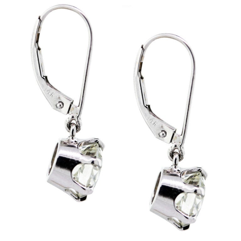 These Diamond Dangle Drop Earrings feature 2 huge European Cut Diamonds on 14K White Gold settings. One Stone is 1.59ct, One Stone is 1.53ct. Both Stones are K in Color and VS2 in Clarity. The earrings have Lever Backs.