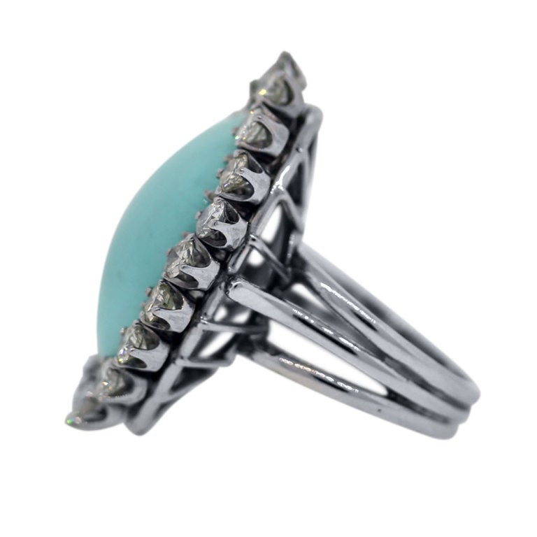This Dinner Ring is set in a 14k White Gold Diamond setting. There are approximately 1.5ctw of diamonds. Diamond color is H/I and Clarity is VS/SI. The center stone is a turquoise gemstone. This ring will fit a ring size of 5.75.