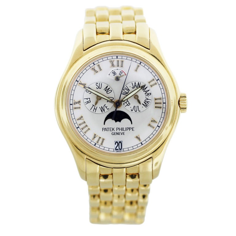 This Patek Philippe 18k yellow gold Ref. 5036/1J Annual Calendar wristwatch has a case diameter of 37 mm. The dial is white with yellow gold Roman numerals. The dial features day and month indicator, moon phase and power reserve. The case has a