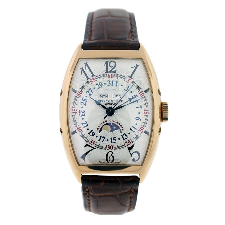 This Franck Muller 18k rose gold Master Calendar wristwatch, Ref. 6850 MC L, has a case diameter of 32 mm. The silvered engine-turned dial shows a perpetual calendar and moon phase. The strap is brown crocodile and is adjustable to an 8'' wrist.