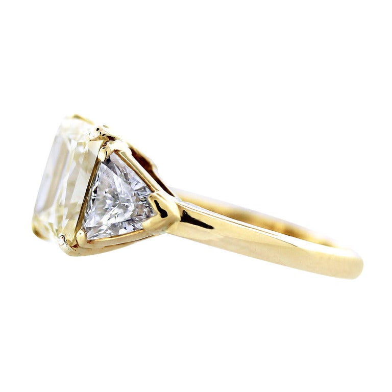 Style 	Van Cleef & Arpels Engagement Ring
Main Diamond 	Radiant Cut
Diamond Carat Weight 	Main Diamond is 3.32ctw
Diamond Color 	Fancy Yellow
Diamond Clarity 	VS2
Diamond Measurements 	8.57 x 8.06 x 5.14 mm
Mounting Details 	18K Yellow Gold