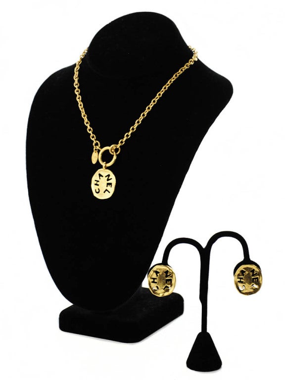 Gold industrial style Chanel necklace and clip-on earring set. Necklace and Earrings are identical in size and design. Necklace has front springring closure. Necklace measures 15