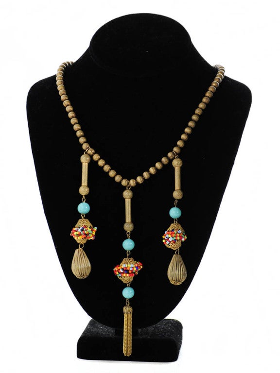 Vintage Miriam Haskell Egyptian inspired necklace with three drop ornaments. The drop ornaments feature round teal glass beads, intricate metal bell caps with tiny multi-color glass bead wire wrap in between. Middle ornament has two teal glass beads