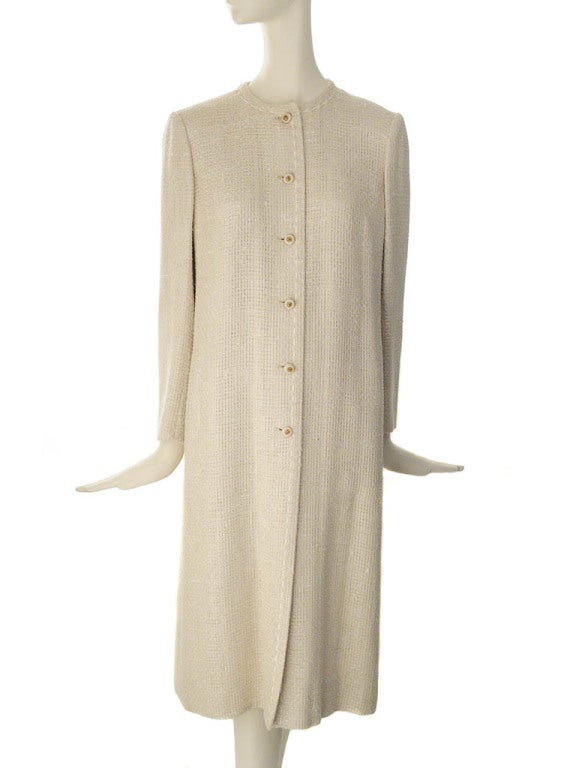 Vintage Chanel Creations long lightweight evening jacket in iconic ivory tweed. Jacket has round neckline, gold tone lion head six-button front closure, contrasting top stitching, three-button sleeve cuff and side seam pockets. Fully lined in silk