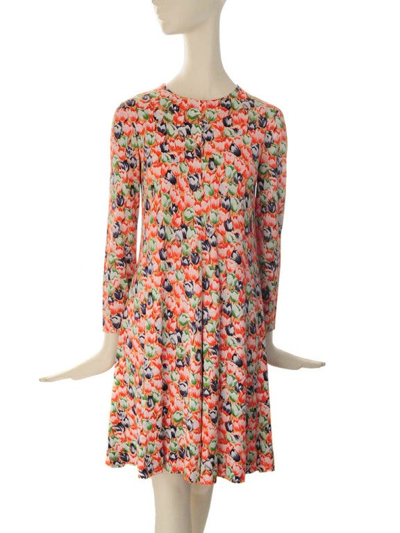 Vintage Diane Von Furstenburg tulip print sheath dress in coral jersey knit. Tulips are navy blue, green and red with white highlight and brown stems. The dress features a rounded neckline, Long sleeves, center front and back seam and back centered