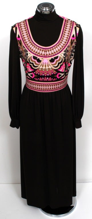Maxi dress presented by Mr. Dino in brown with mock turtleneck, funnel cuff long sleeves and gathered dropped empire waist. This dress features a unique tribal motif in neutral colors contrasted by two shades of pink. Dress is unlined and has a back