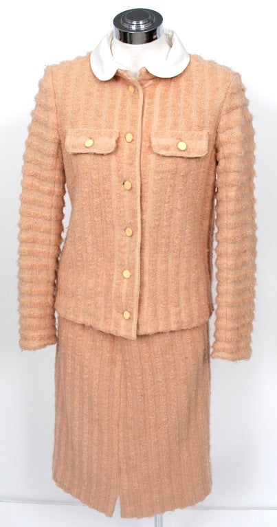 Two piece skirt suit presented by Courreges in salmon colored chenille wool features a detachable white cotton Peter Pan collar that converts to a nehru collar, six button front closure, floating pocket flaps and cuffs. Matching front vent skirt,